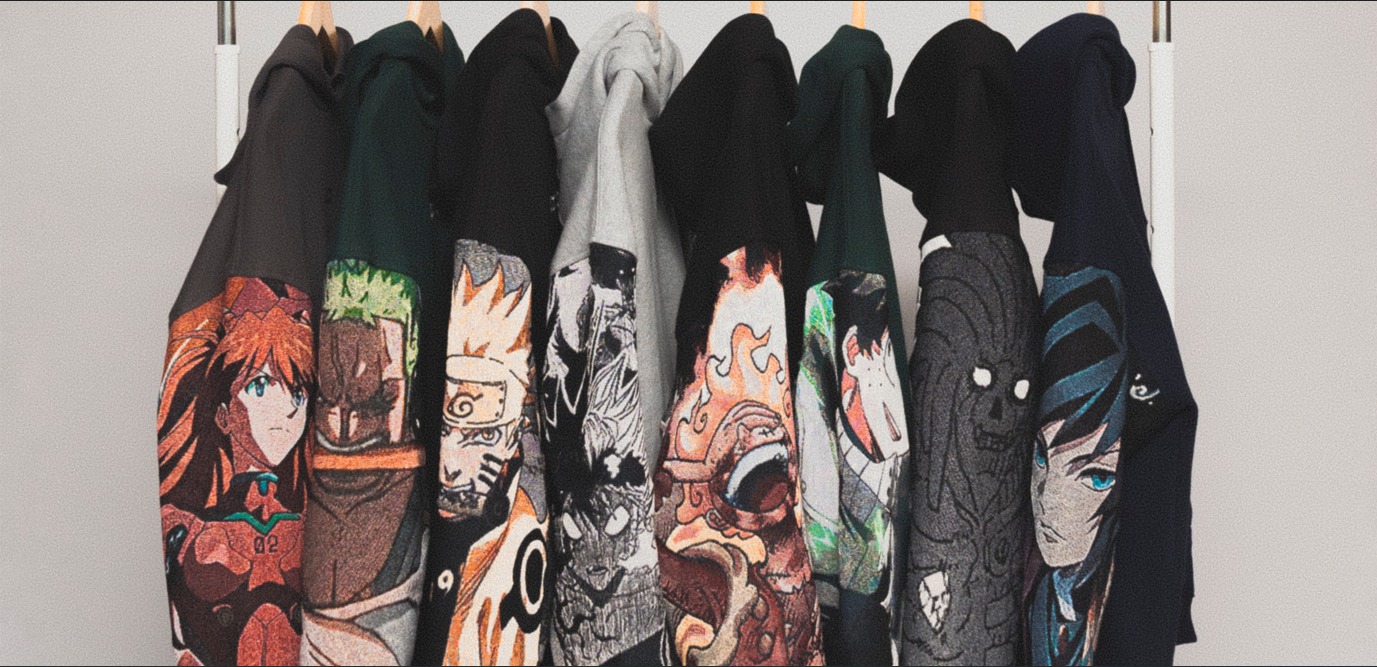Deretan hoodie dengan desain lengan bergambar karakter anime tergantung di rak pakaian putih